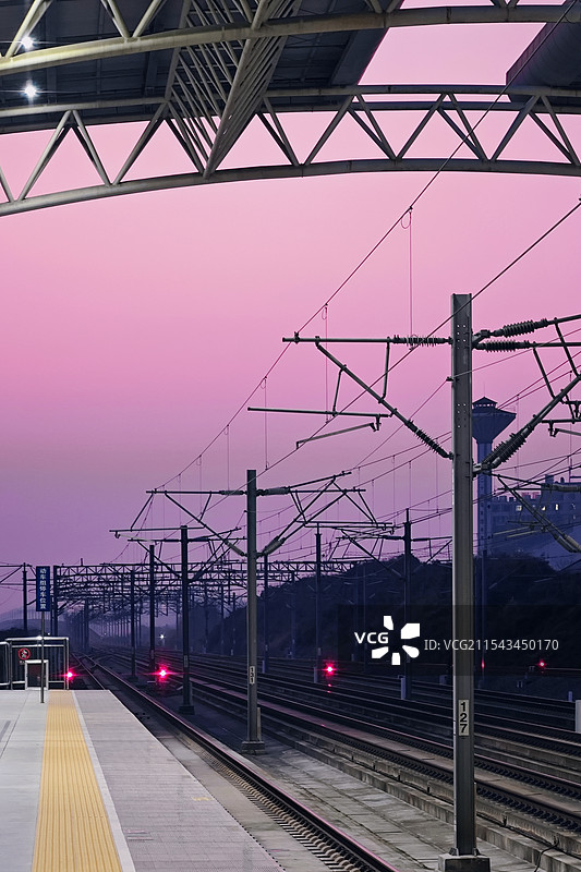 温柔粉色晚霞下的高铁车站轨道延伸到远方图片素材