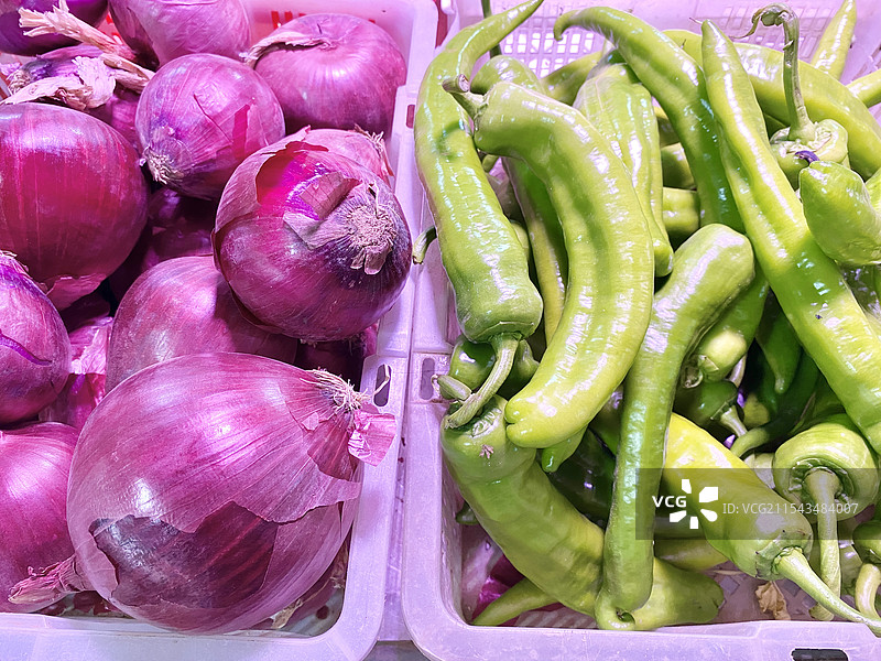 菜市场摊档上篮子里出售的紫洋葱和尖椒的特写镜头图片素材