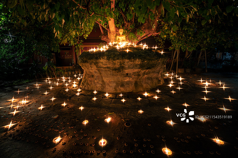 佛像前点蜡烛祈福图片素材