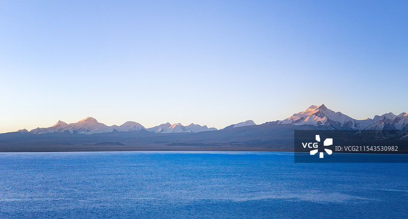 西藏日喀则佩枯措和远方的岗彭庆与希夏邦马日出日照金山图片素材