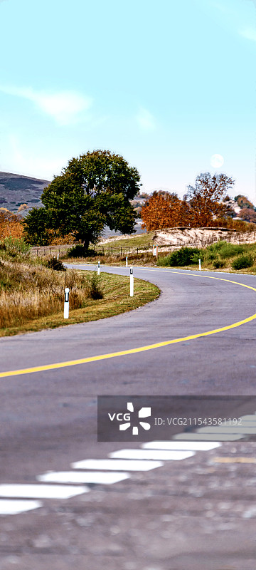 内蒙古赤峰克什克腾乌兰布统森林草原秋色中公路上行驶的汽车图片素材