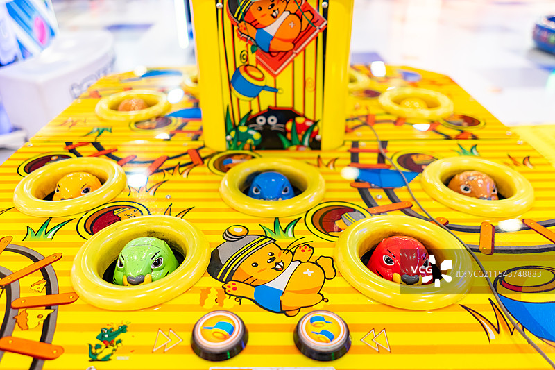 中国儿童游戏机拍摄主题，一只手拿着锤子玩打地鼠游戏机机器设备用品，室内无人图像摄影图片素材