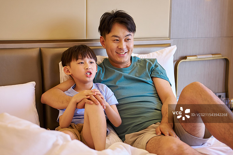 快乐父子坐在床上玩耍图片素材