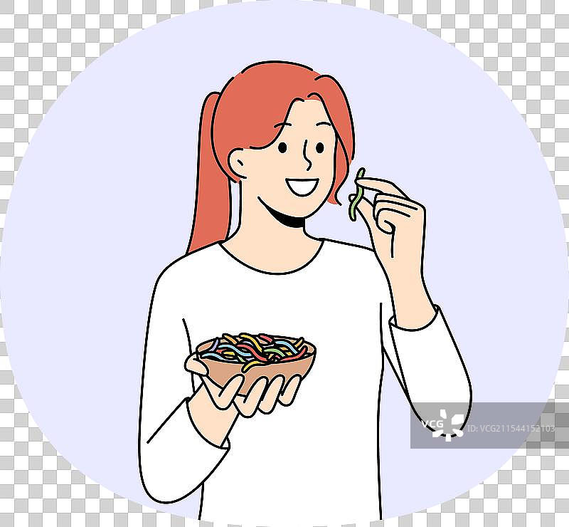 微笑的女孩在吃五颜六色的软糖虫图片素材