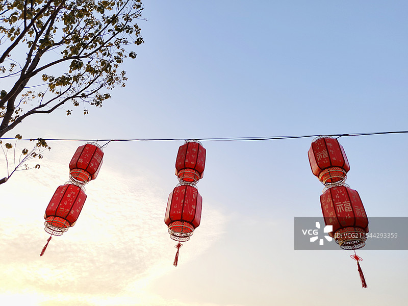 蓝天白云背景下 悬挂的 大红灯笼 新年节日气氛 夕阳图片素材