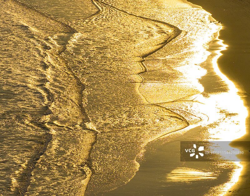 阳光照射在金色的沙滩上，美丽的风景图片素材
