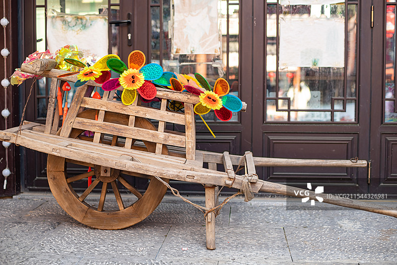 中国传统文化拍摄主题，一辆古老的木制的推车和上面的风车装饰物，室内无人图像摄影图片素材
