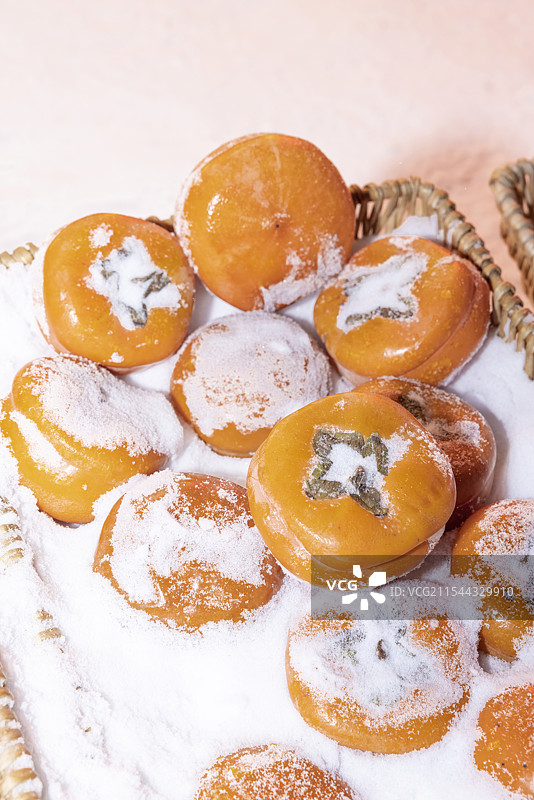 冬天雪里的金黄色的磨盘大冻柿子图片素材