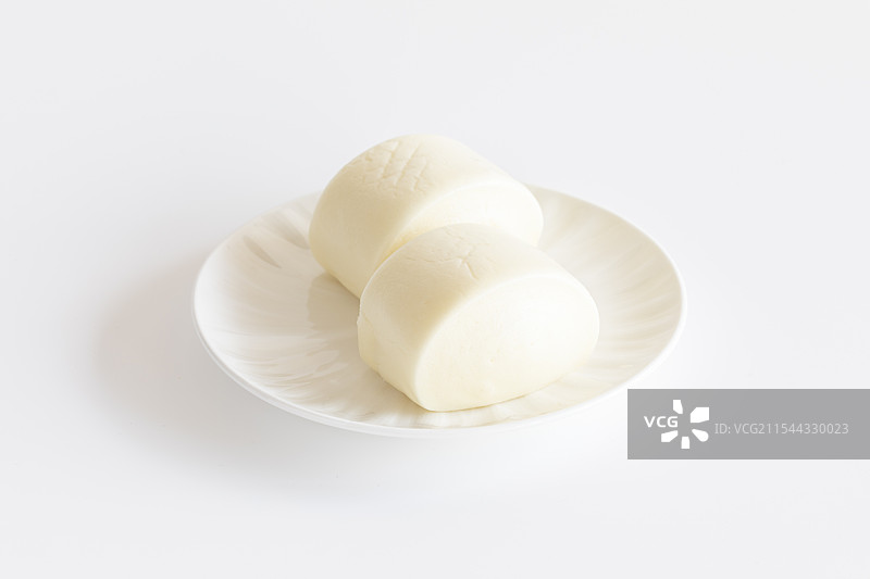 白色背景下盘子里刀切馒头的高角度视图图片素材