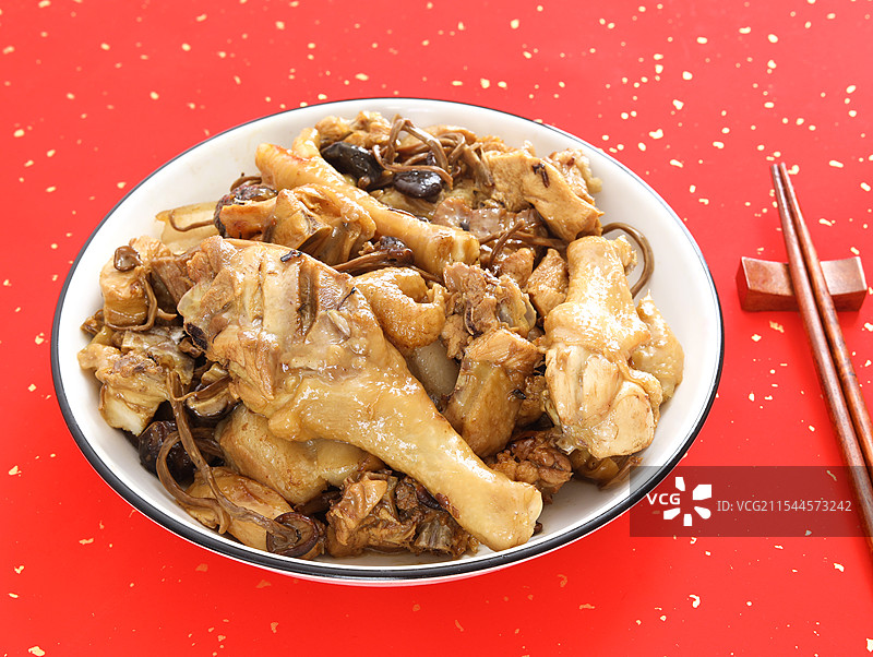 红色背景上的一盘子东北菜年夜饭小鸡炖蘑菇图片素材