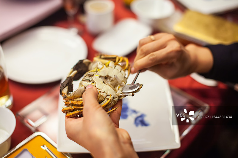 苏州阳澄湖，一位中国女性正在用蟹八件工具品尝大闸蟹图片素材