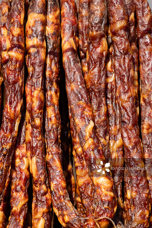年货市场上的春节特色食品烟熏腊肉制品图片素材