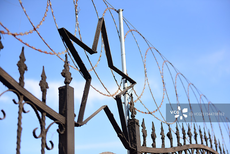 蓝天下带刺铁丝网的低角度视图图片素材