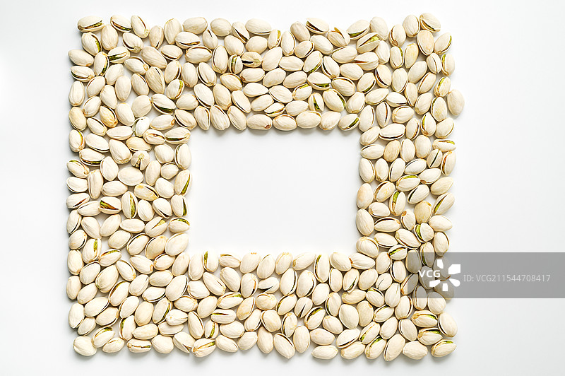 白色背景前一堆开心果中间有矩形留白图片素材