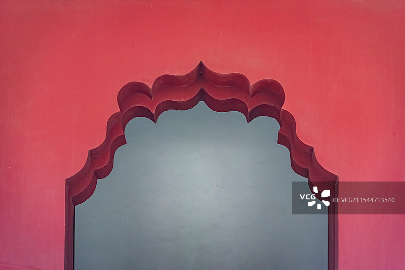 红色拱形门框饰以精致的波浪形图案，内部深邃的灰色与红色背景形成对比，营造出神秘而优雅的氛围。图片素材