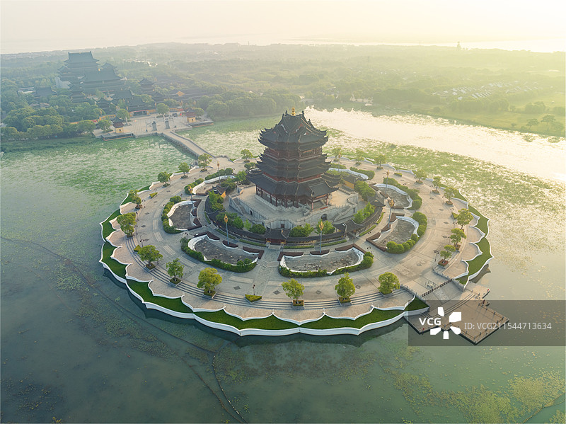 金色琉璃瓦屋顶的中国风格建筑，周围环绕绿意，鸟瞰下壮丽非凡。图片素材