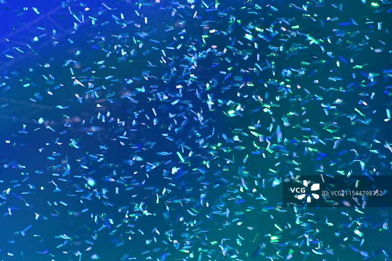 室内空中飞舞的彩色发光纸屑背景图片素材