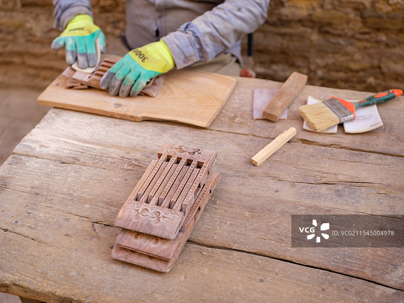 希瓦古城的手工艺人正在制作木制工艺品图片素材