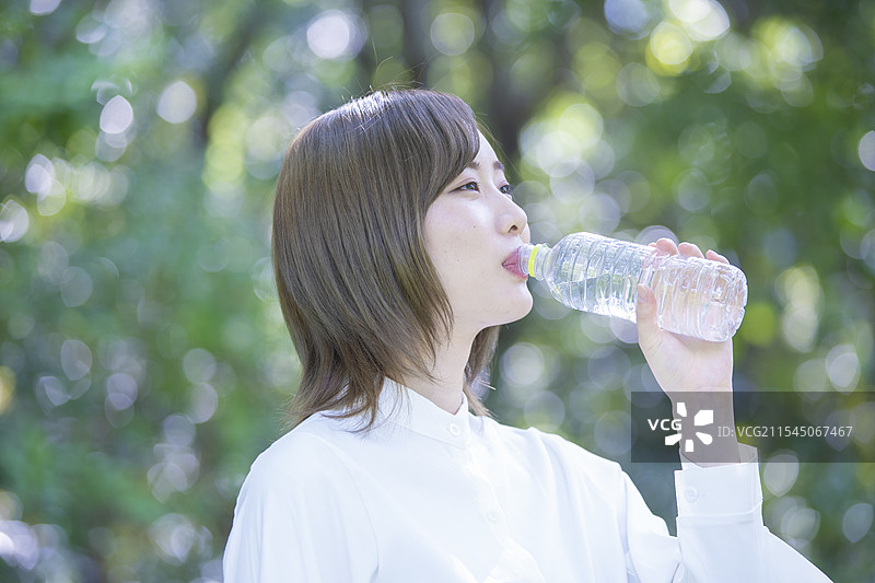 公园里喝水的女人图片素材