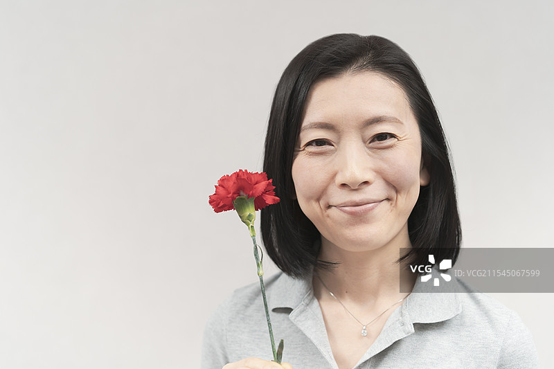 微笑的女人手捧康乃馨图片素材
