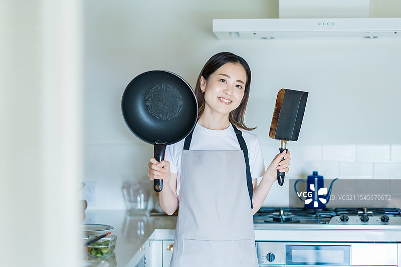 女人在厨房里拿着锅图片素材