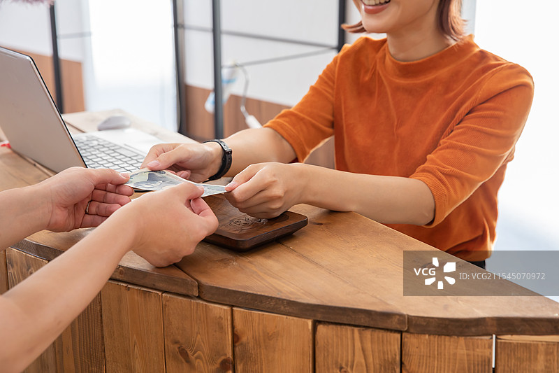 员工和顾客的手在支付账单图片素材