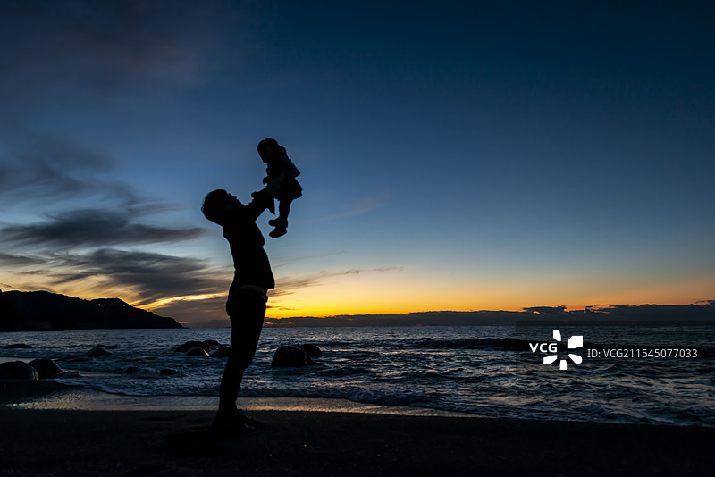 父母与孩子在落日余晖中的剪影图片素材