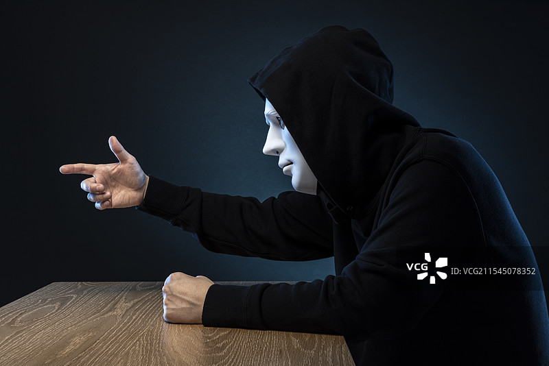 戴面具的男人，桌子。图片素材