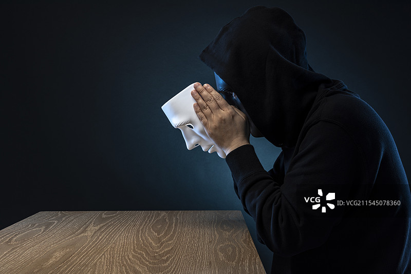 戴面具的男人，桌子。图片素材