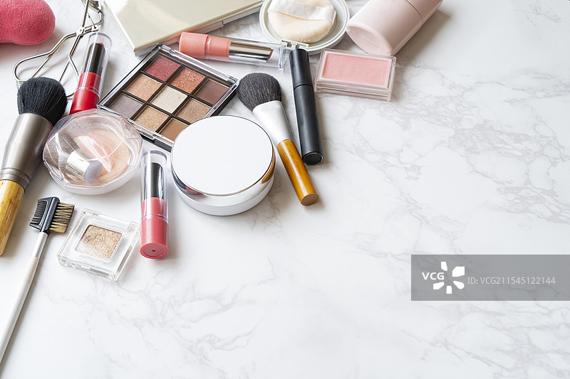 大理石台面上放置的一组化妆工具的俯视图，带有边缘。图片素材