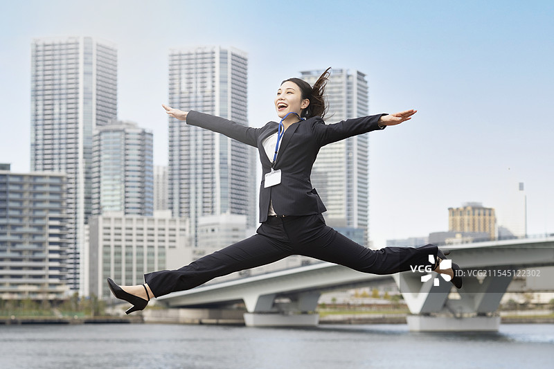 年轻的女商人/求职者微笑着跳跃图片素材