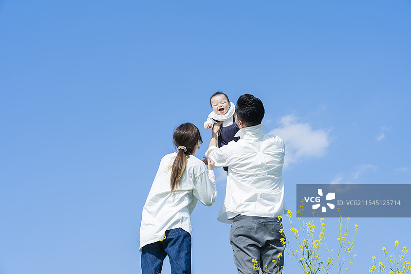 父母在蓝天之下高高举起他们的宝宝图片素材
