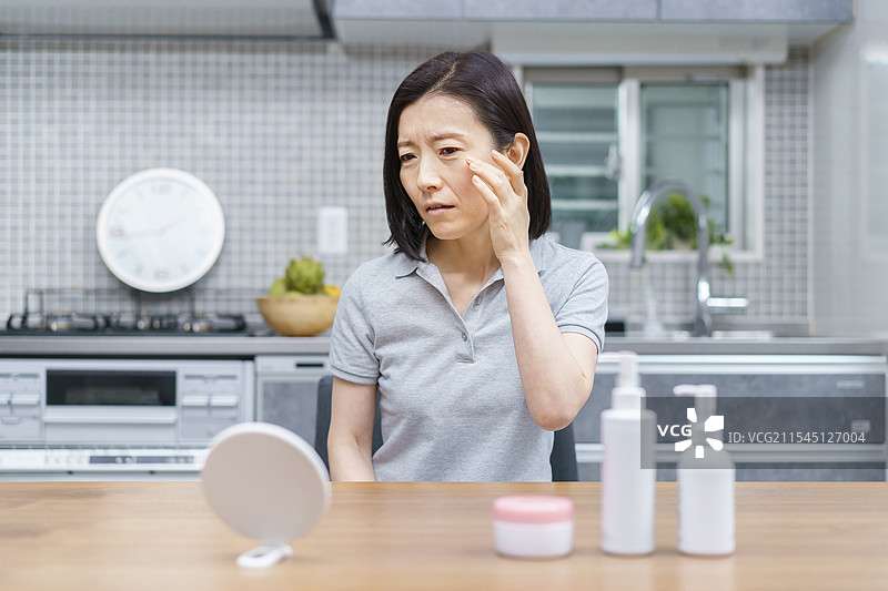 中年女性焦虑地检查自己的皮肤图片素材