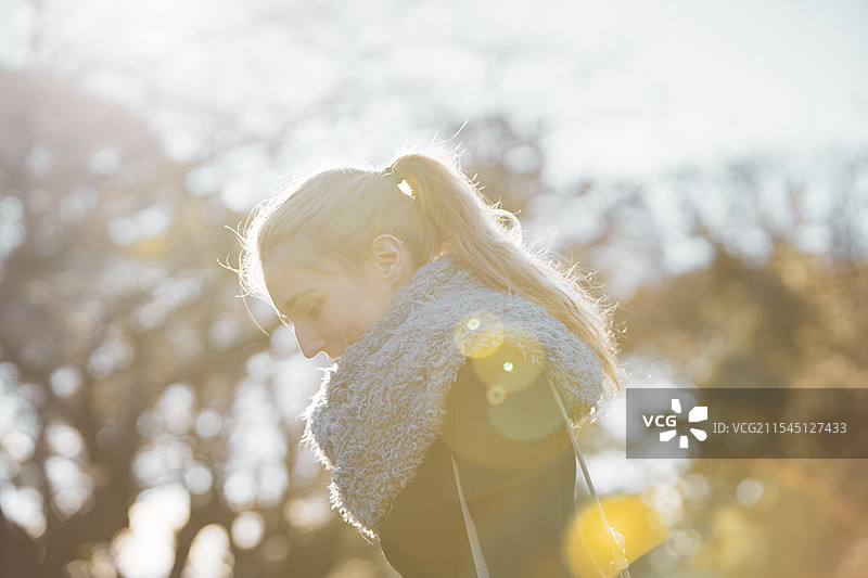 背光下的女人在公园散步图片素材
