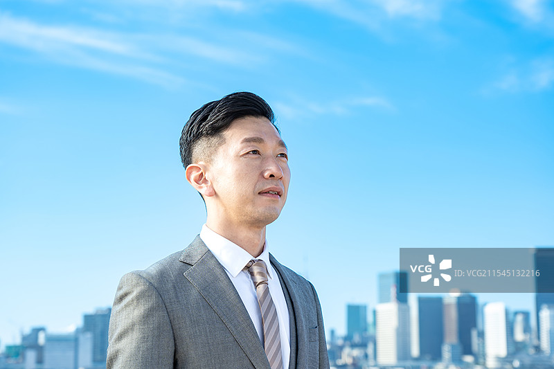 商人肖像，背景是蓝天和建筑物图片素材