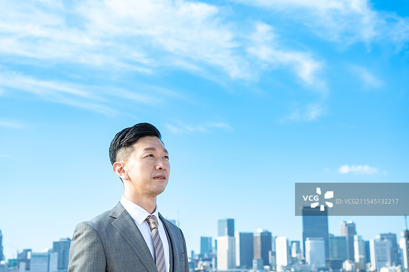 商人肖像，背景是蓝天和建筑物图片素材