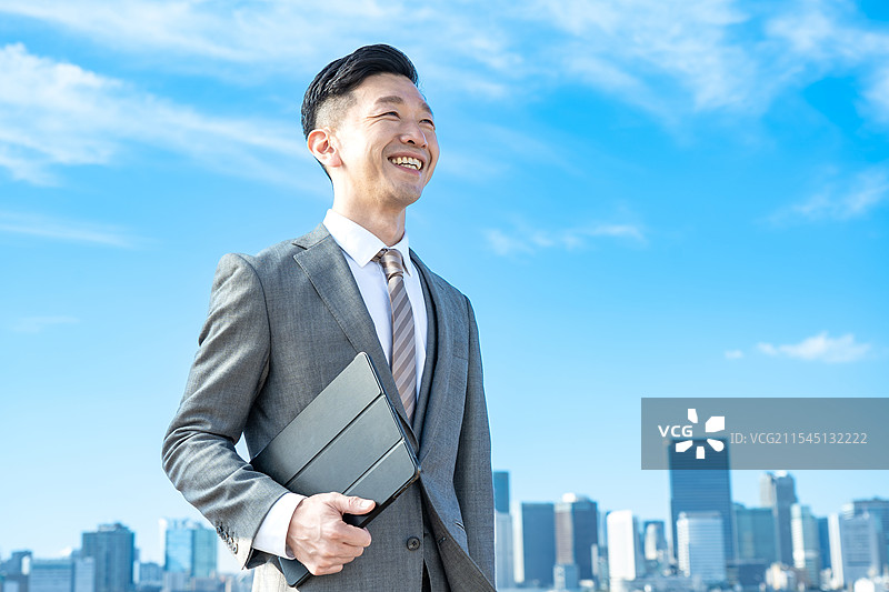 商人肖像，背景是蓝天和建筑物图片素材