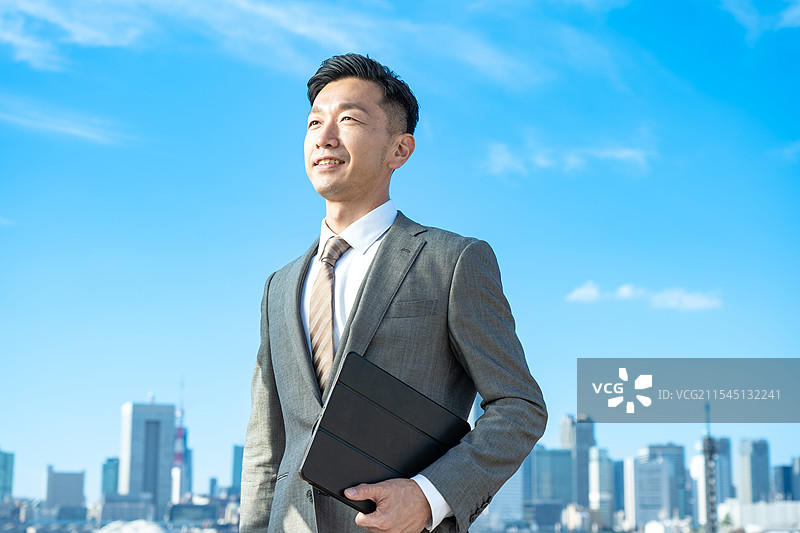 商人肖像，背景是蓝天和建筑物图片素材