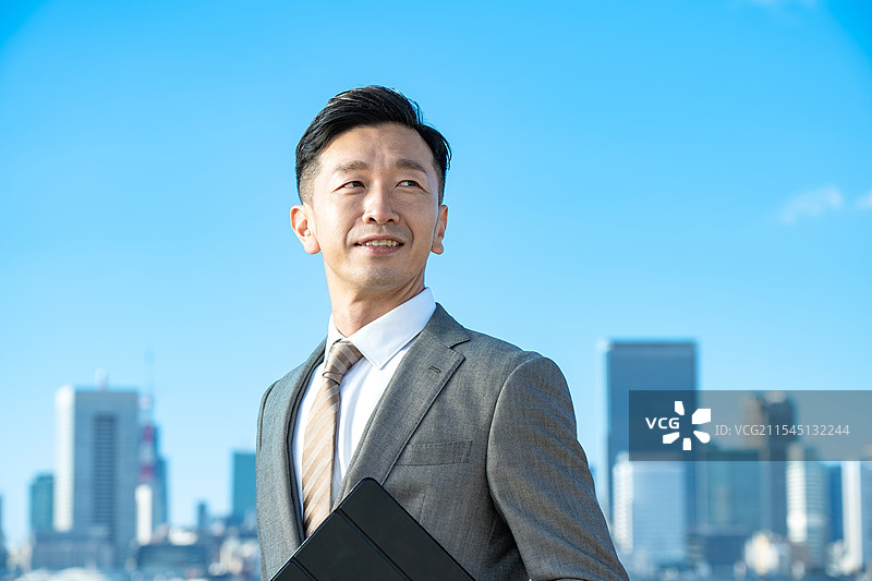 商人肖像，背景是蓝天和建筑物图片素材