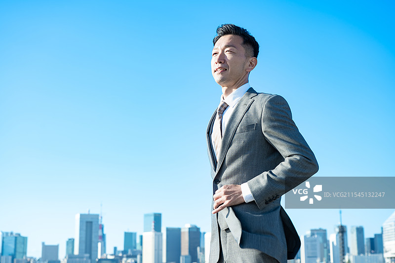 商人肖像，背景是蓝天和建筑物图片素材