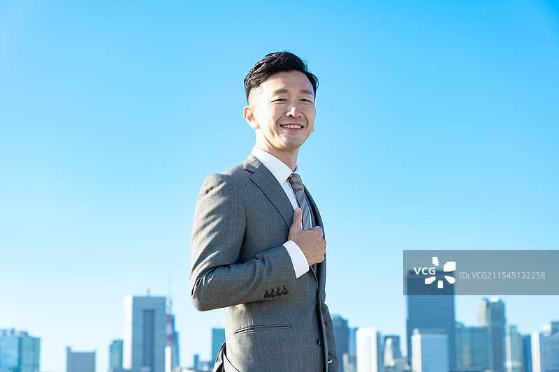 商人肖像，背景是蓝天和建筑物图片素材