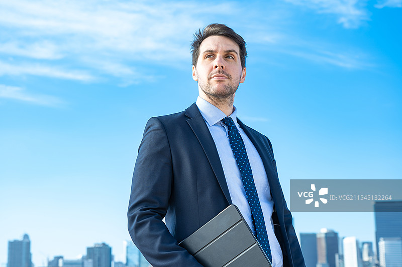 商人肖像，背景是蓝天和建筑物图片素材