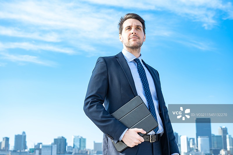 商人肖像，背景是蓝天和建筑物图片素材