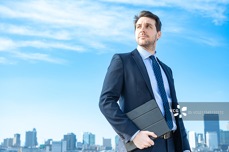 商人肖像，背景是蓝天和建筑物图片素材