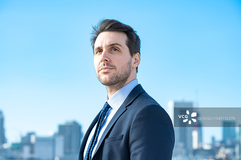 商人肖像，背景是蓝天和建筑物图片素材