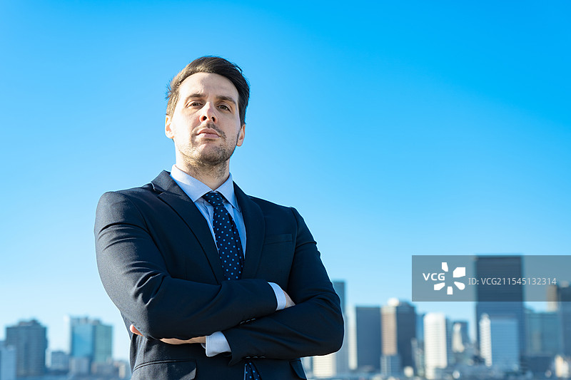 商人肖像，背景是蓝天和建筑物图片素材