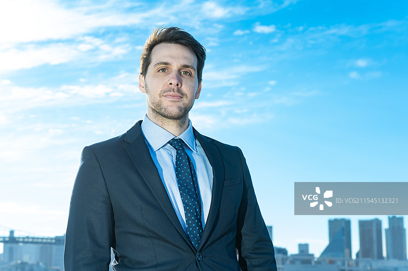 商人肖像，背景是蓝天和建筑物图片素材
