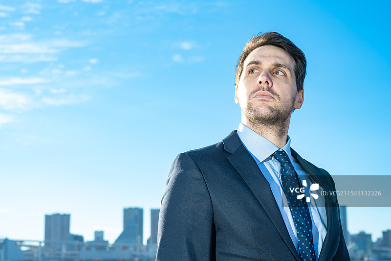 商人肖像，背景是蓝天和建筑物图片素材