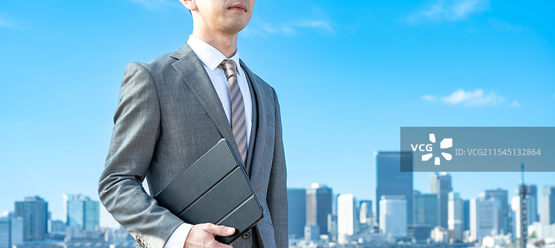 商人在蓝天和建筑物的背景下图片素材