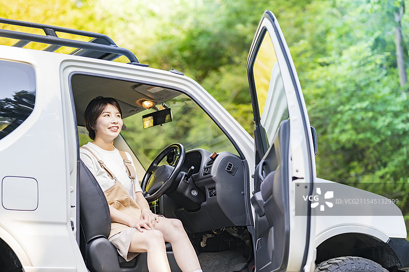 年轻女性坐在汽车的驾驶座上图片素材
